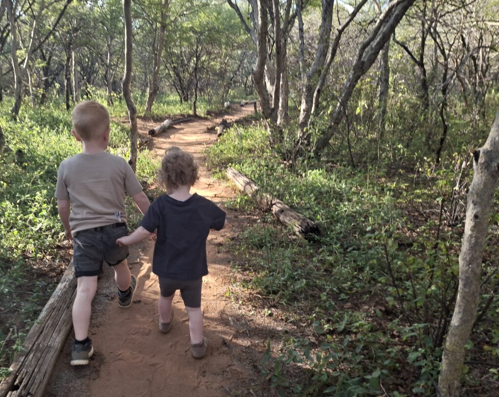 Zwei Kinder sind zu Fuß unterwegs im Busch in Südafrika